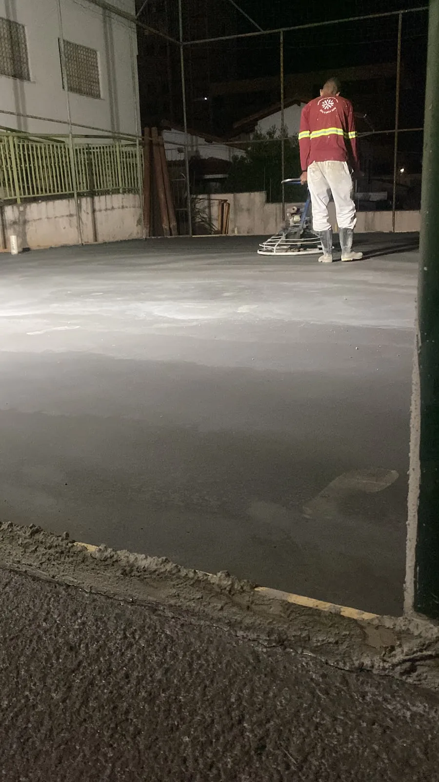 Operador executando acabamento mecanizado do concreto